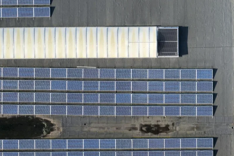 Detail van het PV-veld van bovenaf: rijen zonnepanelen met frames en bevestiging, en een lichtstraat